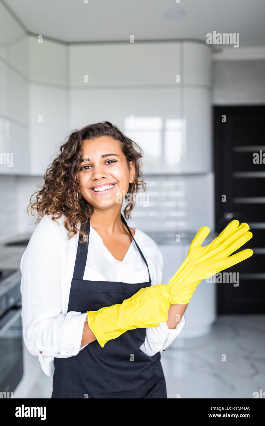 Hand cleaning.Young housewife woman washing dishes in kitchen.Preparing to clean,funny smiling photo with yellow rubber gloves.Smiling young beautiful Stock Photo