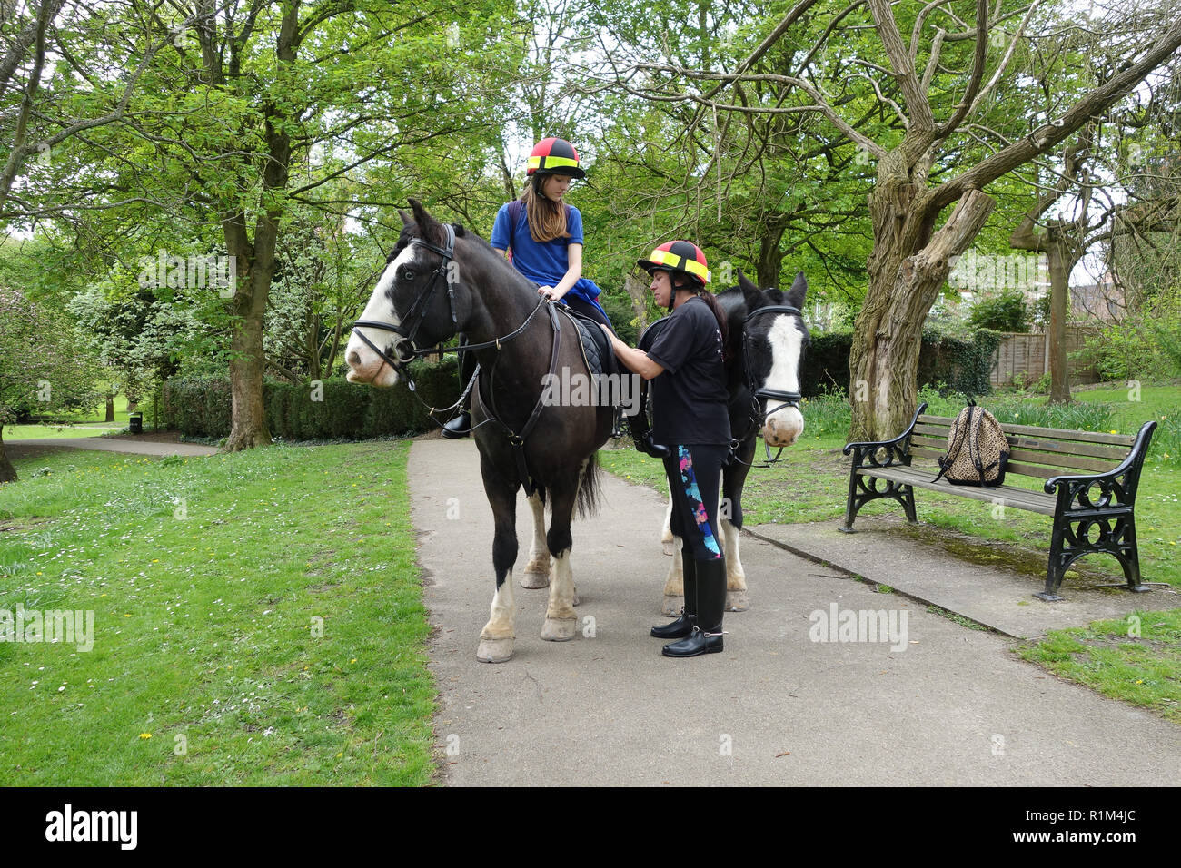 School girl preparing to ride from school on horseback with her mother in Shropshire Uk Stock Photo