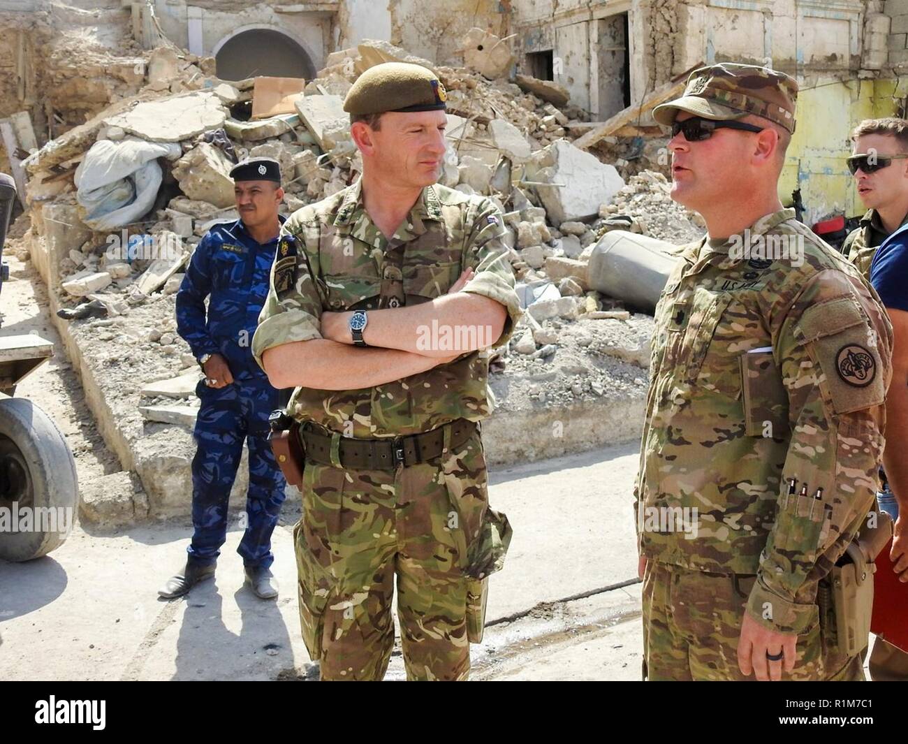 U.S. Army Lt. Col. CJ Kirkpatrick, a squadron commander with 3rd Cavalry Regiment, escorts British Maj. Gen. Christopher Ghika, Combined Joint Task Force – Operation Inherent Resolve Deputy Commander, through the streets of Mosul to observe the destruction caused by ISIS, Oct. 9, 2018. The 3rd Cavalry Regiment is deployed in support of Operation Inherent Resolve, working by, with and through the Iraqi Security Forces and coalition partners to defeat ISIS in areas of Iraq and Syria. Stock Photo