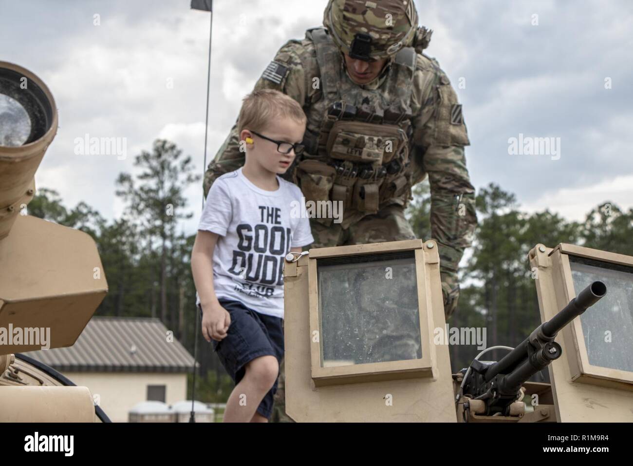 Sgt. Rafael Leyva of 2nd Battalion, 69th Armored Regiment, 2nd Armored Brigade Combat Team, 3rd Infantry Division gives a tour of the M1A1-SA Abrams tank to a child. 2-69 AR hosted a “Family Day” during a gunnery range at Fort Stewart, Ga., Oct. 20.  The event allowed families to see tanks firing and handle weaponry in a safe, controlled setting. Stock Photo