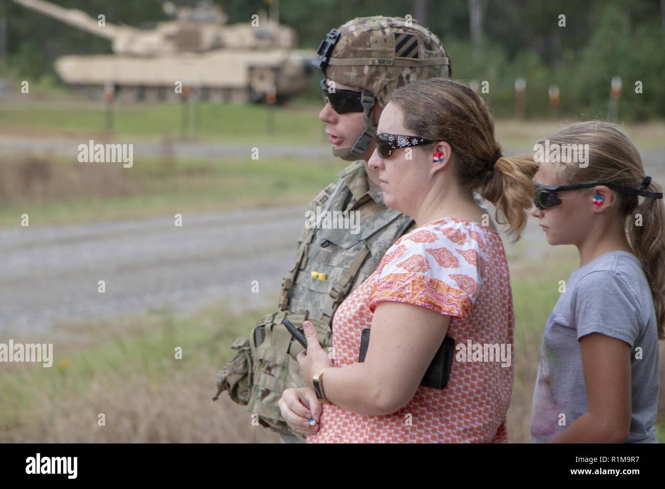 A Soldier and his family, 2nd Battalion, 69th Armored Regiment, 2nd Armored Brigade Combat Team, 3rd Infantry Division watch as M1A1-SA Abrams move around a tank range. 2-69 AR hosted a “Family Day” at Fort Stewart, Ga., Oct. 20. The event allowed families to see tanks firing and handle weaponry in a safe, controlled setting. Stock Photo