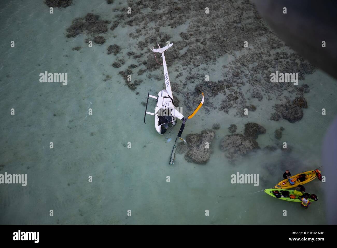A CH-53E Super Stallion with Marine Heavy Helicopter Squadron 463, Marine Aircraft Group 24, provides on scene awareness for a downed civilian helicopter that made an emergency landing on the sandbar in Kaneohe Bay, Hawaii, Oct. 22, 2018. The helicopters were in the area conducting routine operations when notified by the Marine Corps Air Station Kaneohe Air Traffic Control Tower that a civilian aircraft had fallen off of their radar. Marine Corps Base Hawaii also launched watercraft to assist with the rescue if needed. U.S. Marines in Hawaii stand ready to respond during any time of crisis; fr Stock Photo
