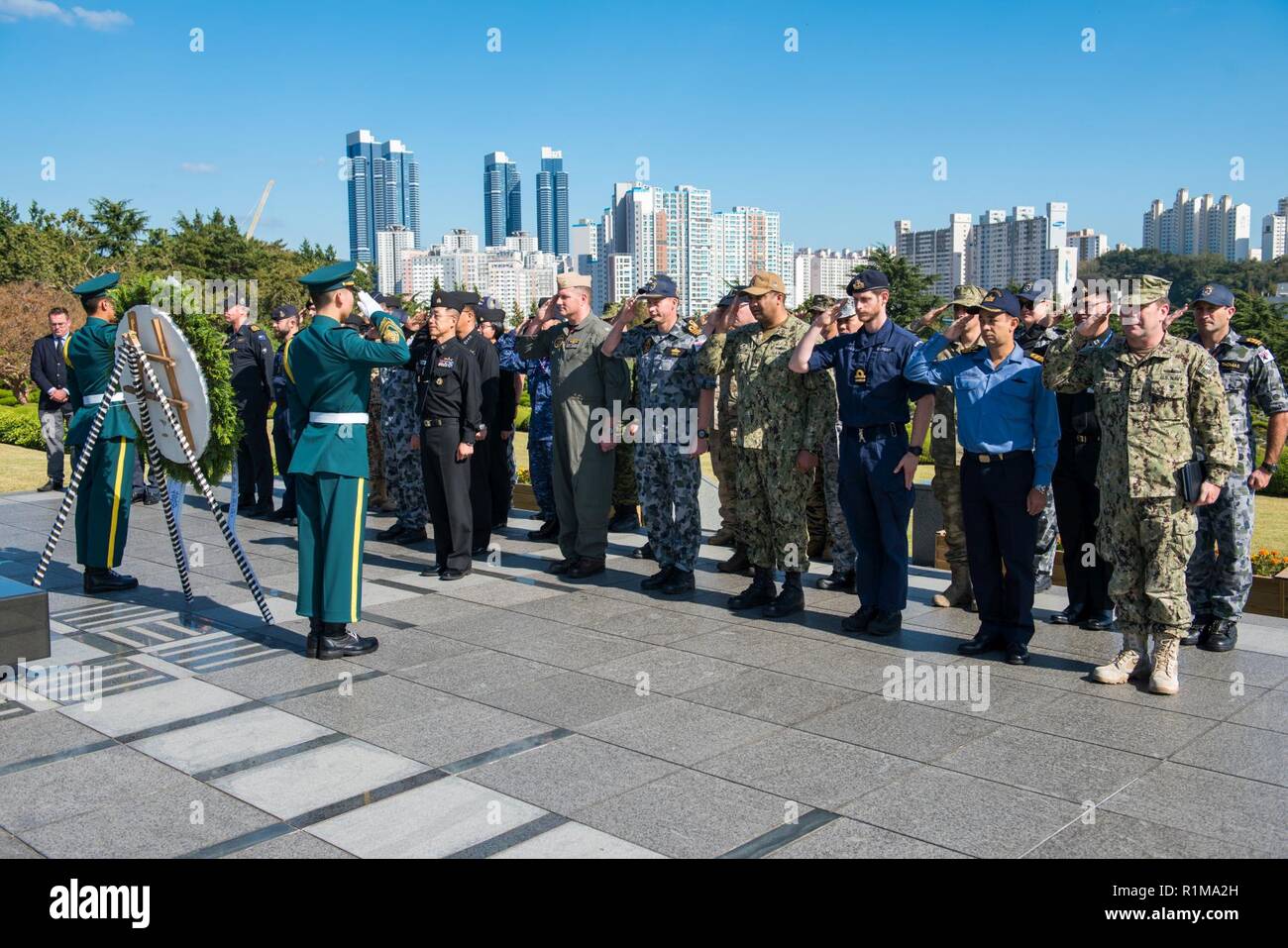 BUSAN, Republic of Korea (Oct. 19, 2018) Service members representing the U.N. Sending States participate in a wreath-laying ceremony at The U.N. Memorial Cemetery in Korea, as a formal conclusion to the Mine Countermeasures Symposium. The ceremony was held in remembrance of Sending States members who fought in the Korean War and are interred at the cemetery. Stock Photo