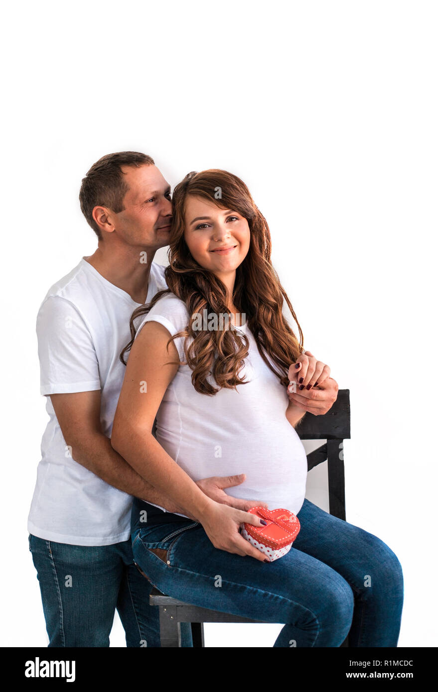 Pregnant couple hug and hold pregnant belly. Stock Photo