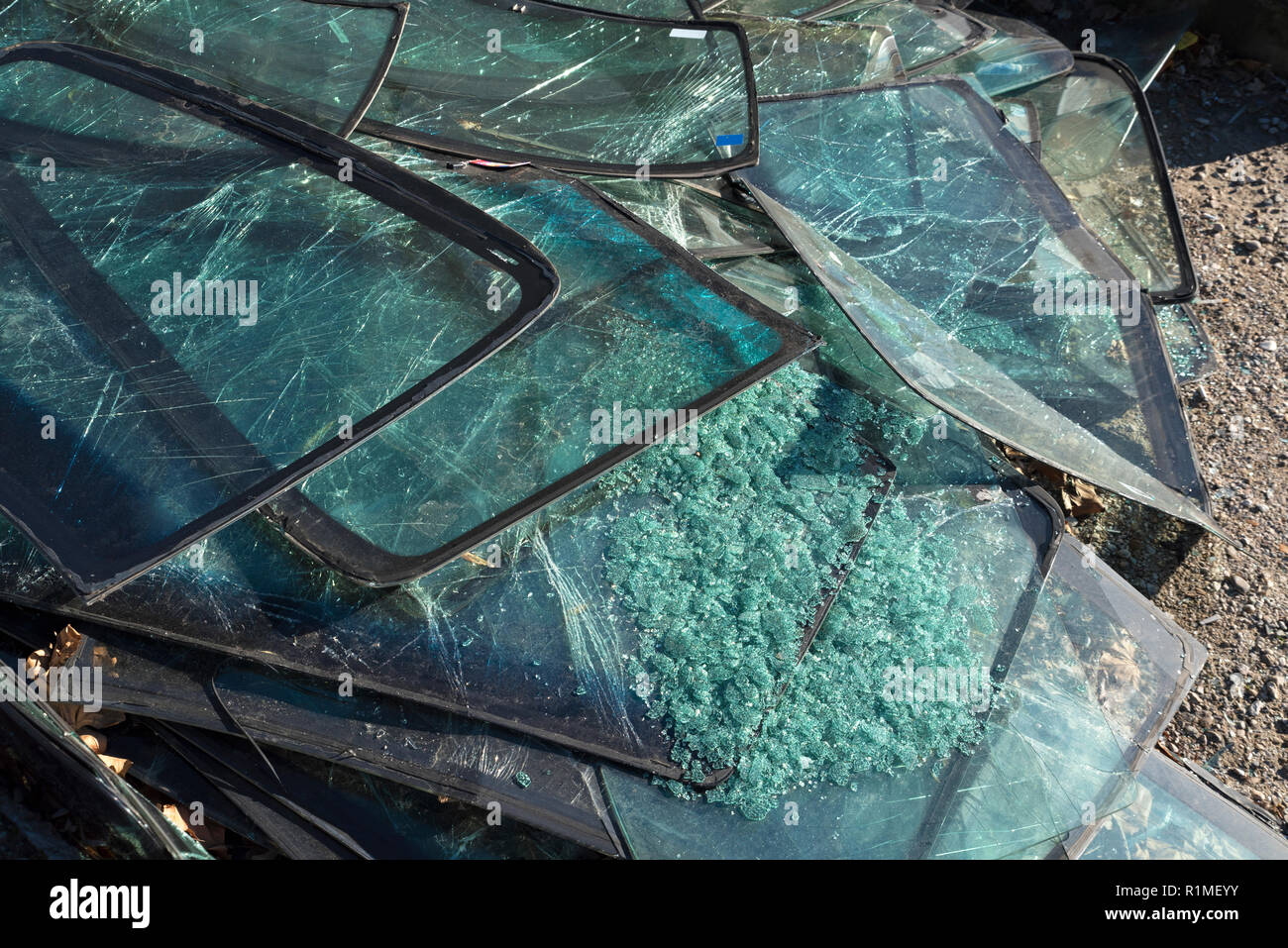 Pile of cracked car windshields on the ground. Selective focus Stock
