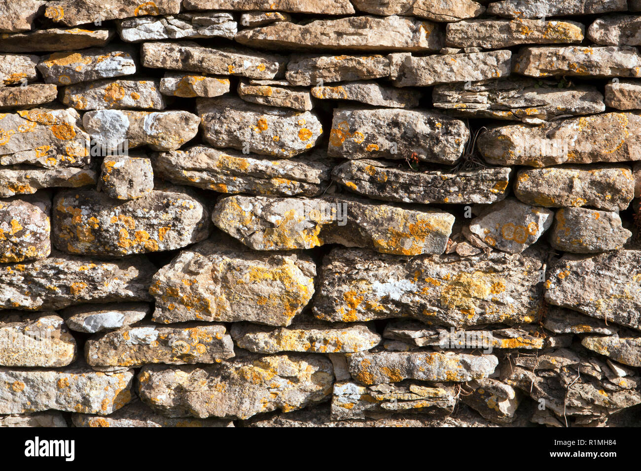 Crumbling old lichen covered Cotswold drystone wall texture Stock Photo