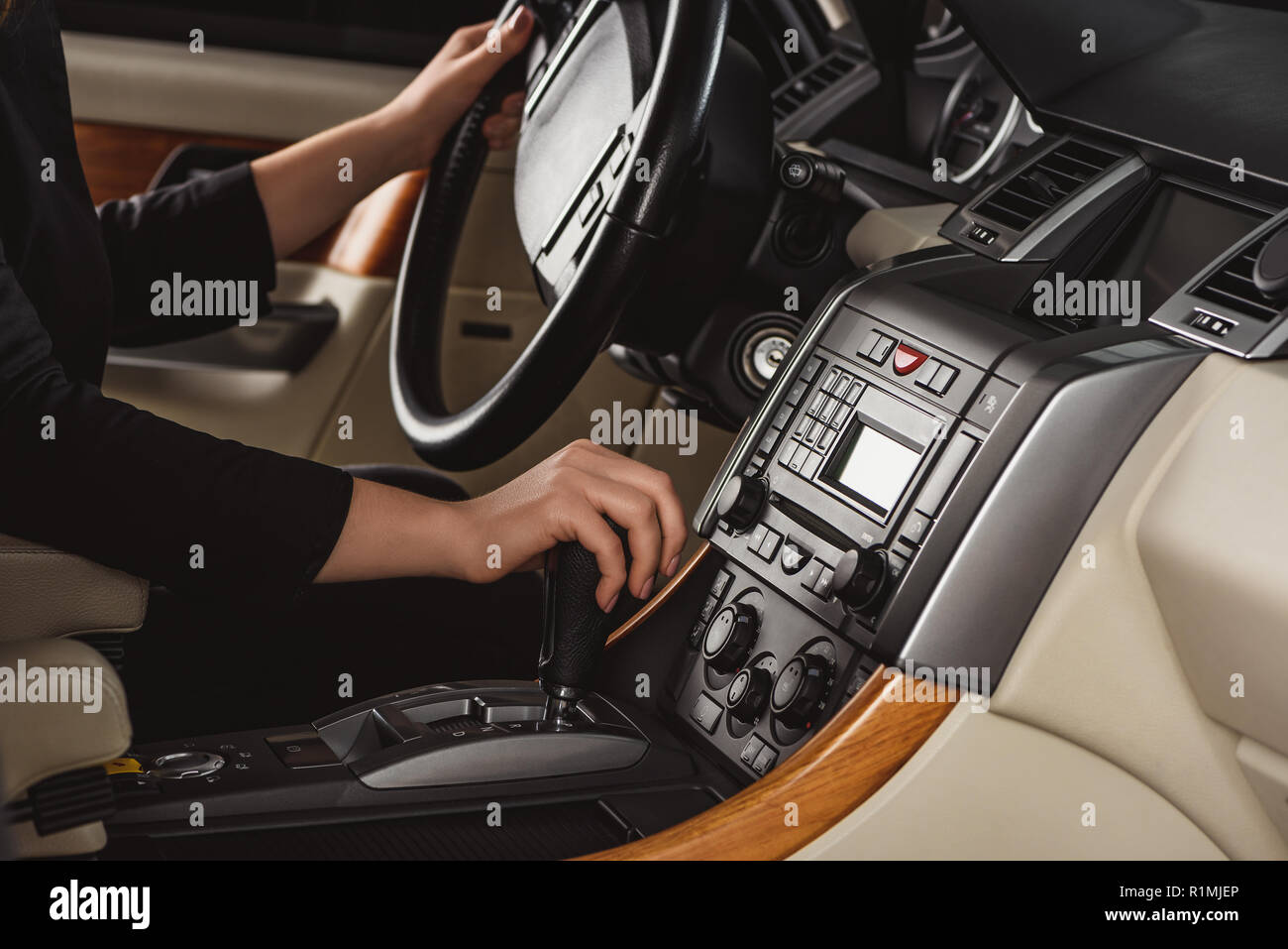 Cropped shot of woman changing gear while driving new car Stock Photo