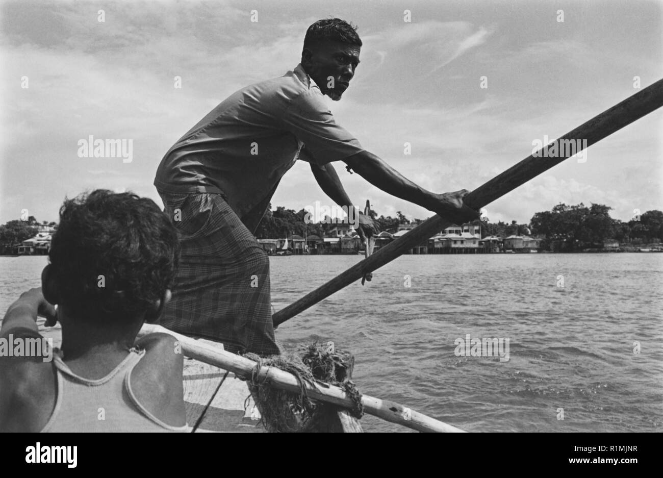 19/4 Boatman and boy on Surma River Sylhet 1980 Stock Photo