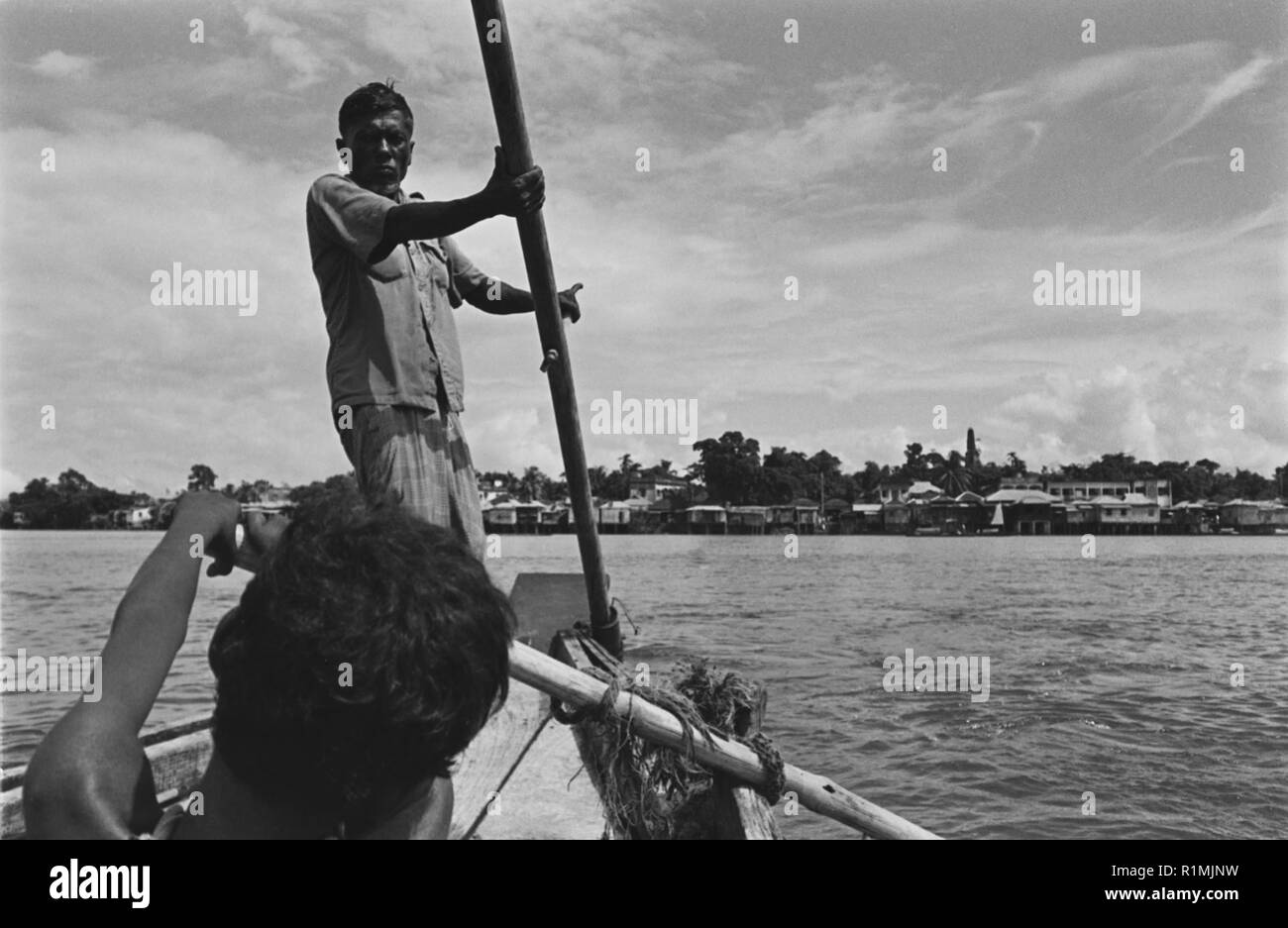 19/6 Boatman and boy on Surma River Sylhet 1980 Stock Photo