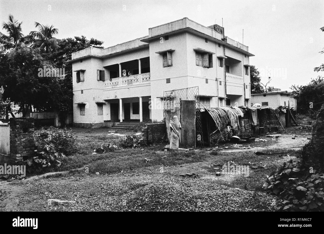 49/25 Basti shacks and large house, Dhaka 1980 Stock Photo