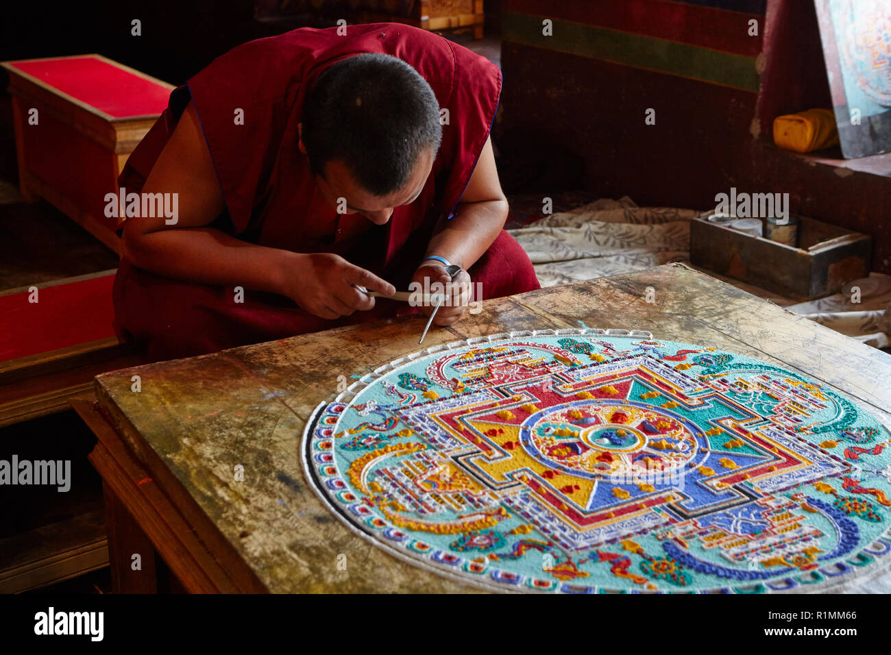 Buddhist monk creating a mandala of colored sand in Lamayuru monastery