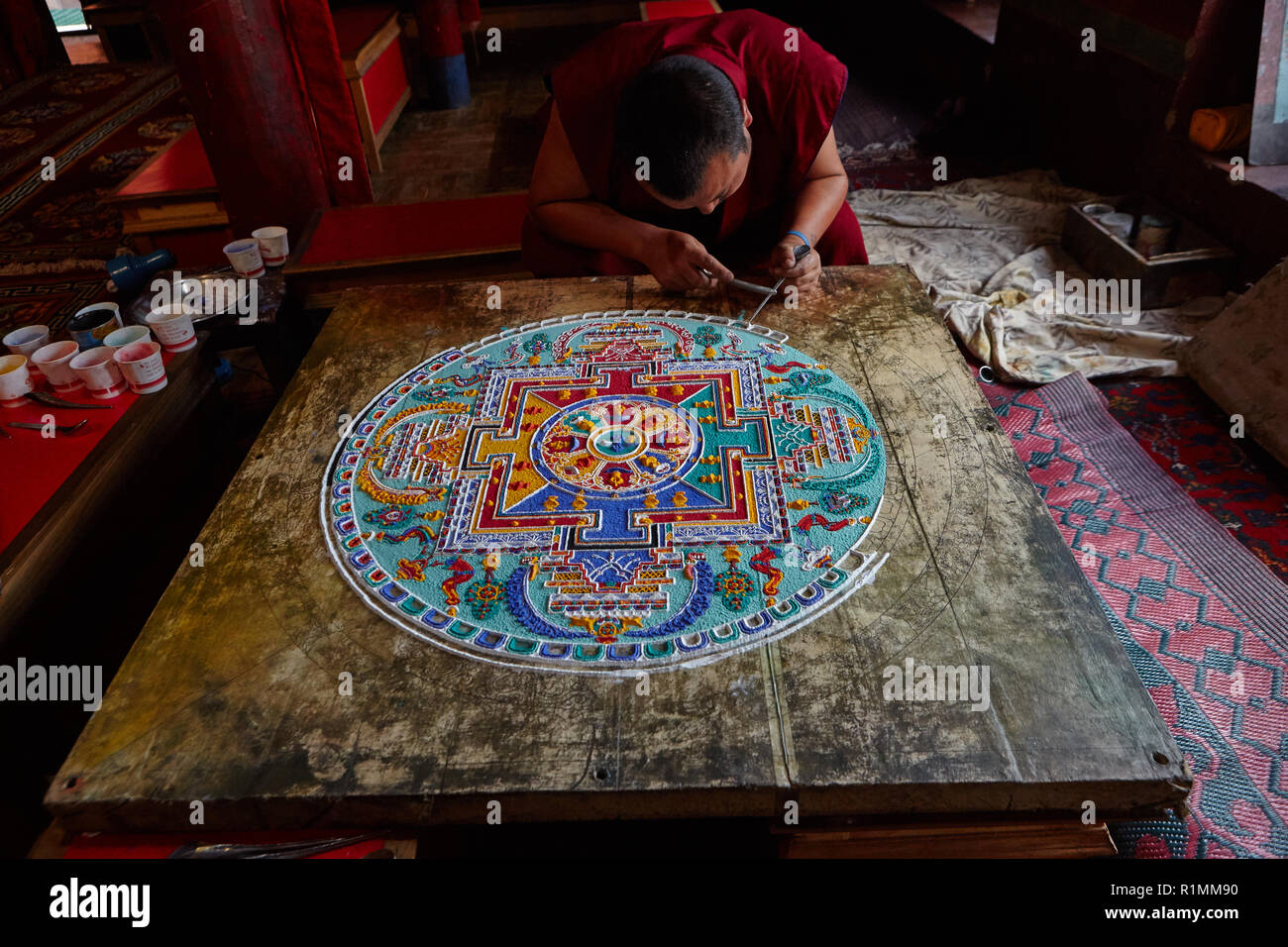 Buddhist monk creating a mandala of colored sand in Lamayuru monastery