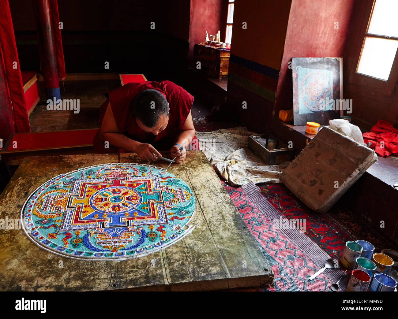 Buddhist monk creating a mandala of color sand in Lamayuru monastery. Ladakh, Jammu and Kashmir, India Stock Photo