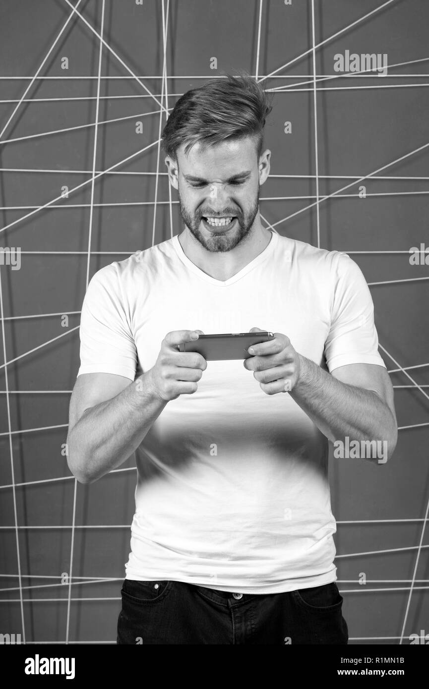 Excited about gaming. Guy play game smartphone gadget. Gamer aggressive  face play online game smartphone. Application for smartphone concept. . Game  addiction concept. Man not inseparable from phone Stock Photo - Alamy