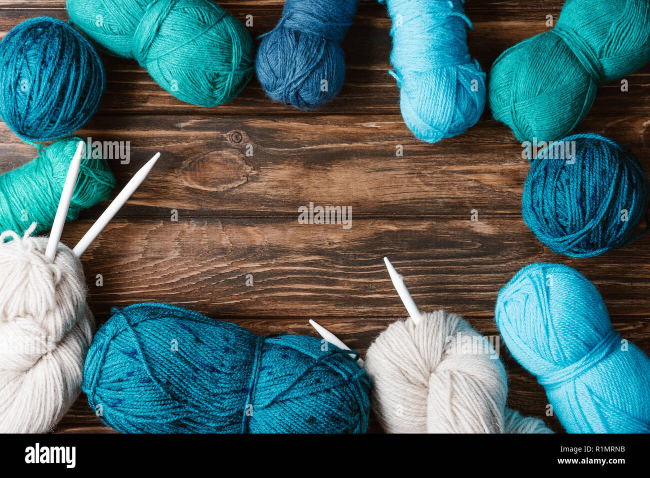 flat lay with arranged yarn clews and knitting needles on wooden surface Stock Photo