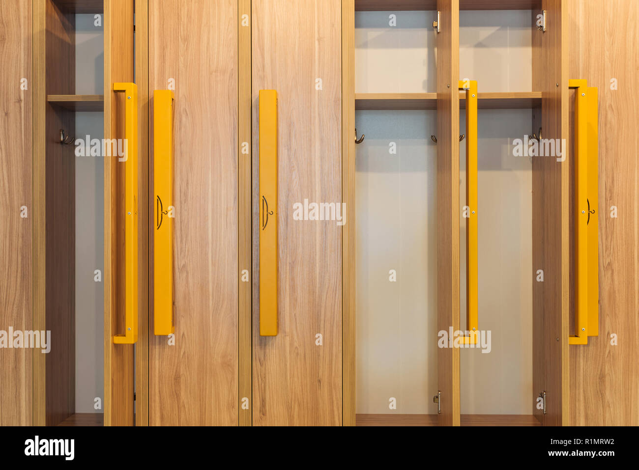 full frame view of wooden lockers with yellow handles in kindergarten cloakroom Stock Photo