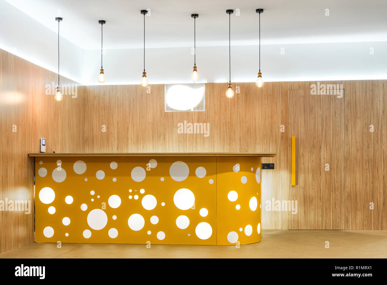 lamps and yellow reception desk in modern kindergarten interior Stock Photo