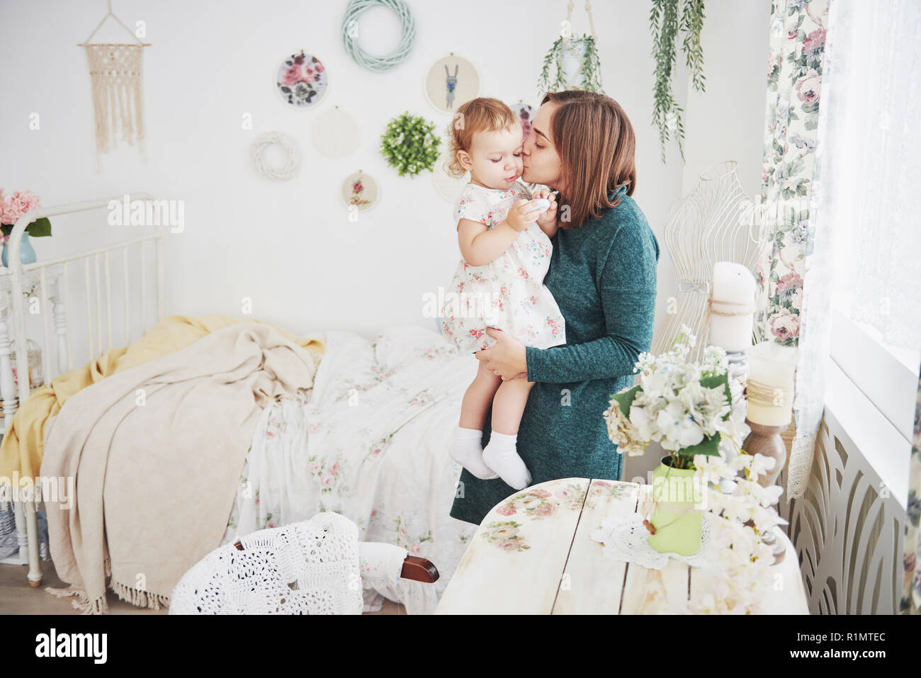 Shot of happy mother playing with her baby in vintage children room. The concept of happy childhood and maternal love Stock Photo
