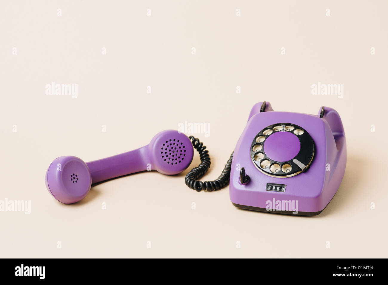 purple retro rotary phone with tube on beige Stock Photo
