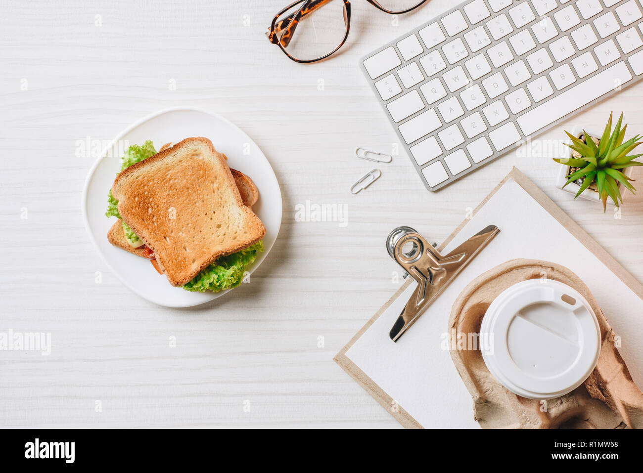 Sandwich and computer keyboard at table in office hi-res stock ...