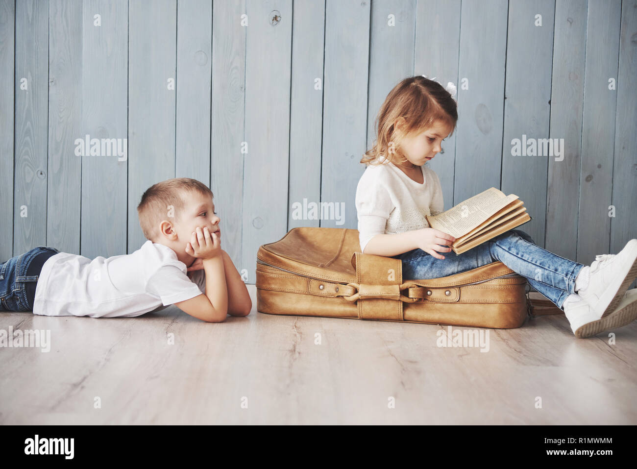 Ready to big travel. Happy little girl and boy reading interesting book ...