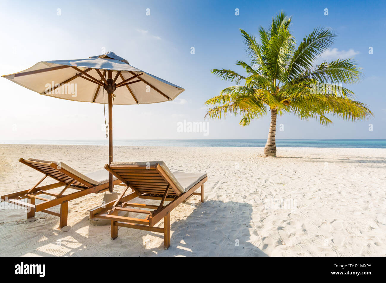 Romantic beach scene, two beach chairs and umbrella. Stock Photo