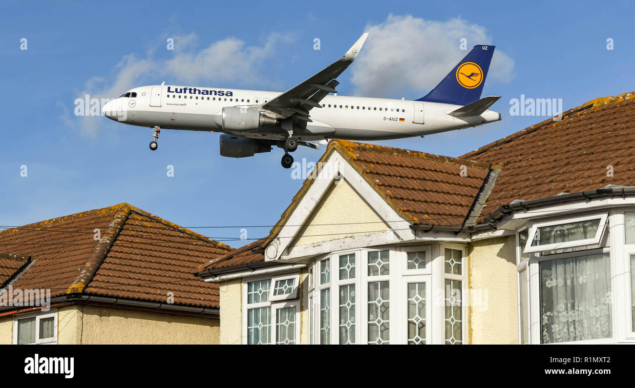 LONDON, ENGLAND - NOVEMBER 2018: Lufthansa Airbus A320 jet flying low over houses before landing at London Heathrow Airport. Stock Photo