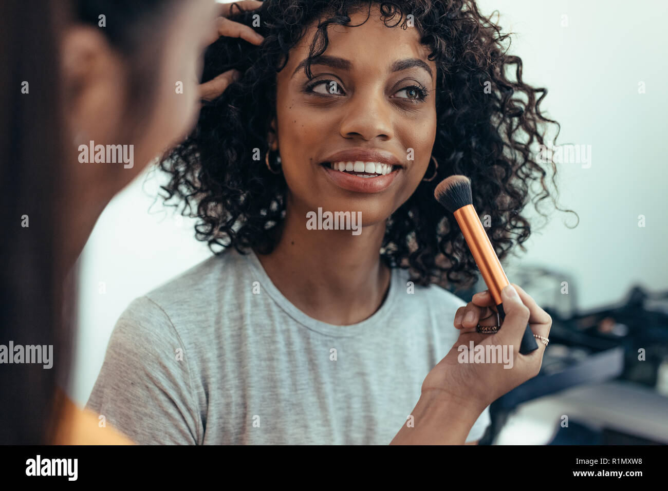 makeup artist preparing a model for a photo shoot. Close up of a model getting ready for photo shoot. Stock Photo