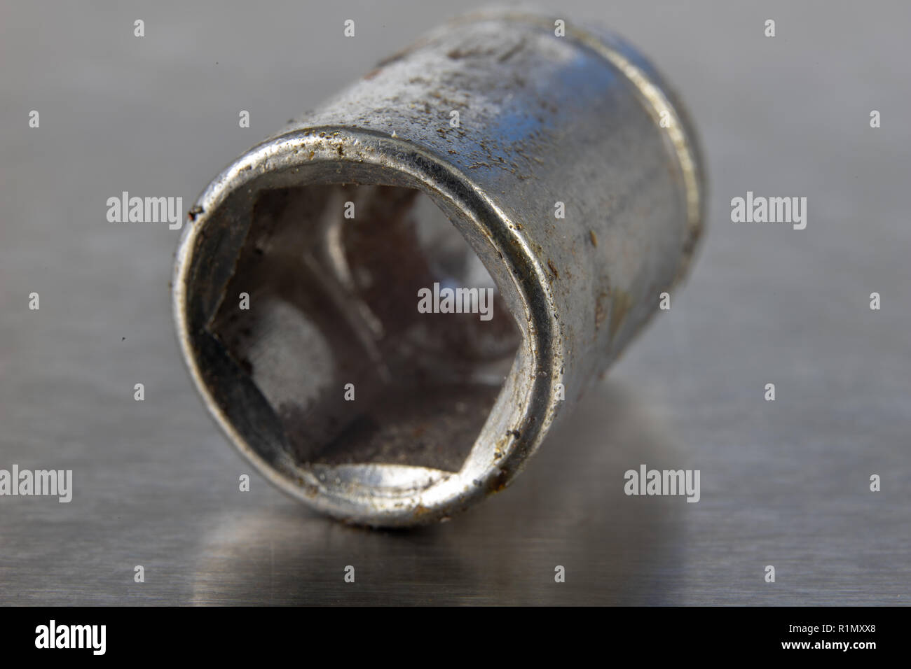 Old socket wrenches with a handle. Accessories for a workshop mechanic on a tin table. Light background. Stock Photo