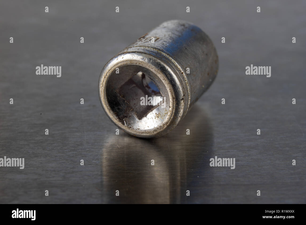 Old socket wrenches with a handle. Accessories for a workshop mechanic on a tin table. Light background. Stock Photo