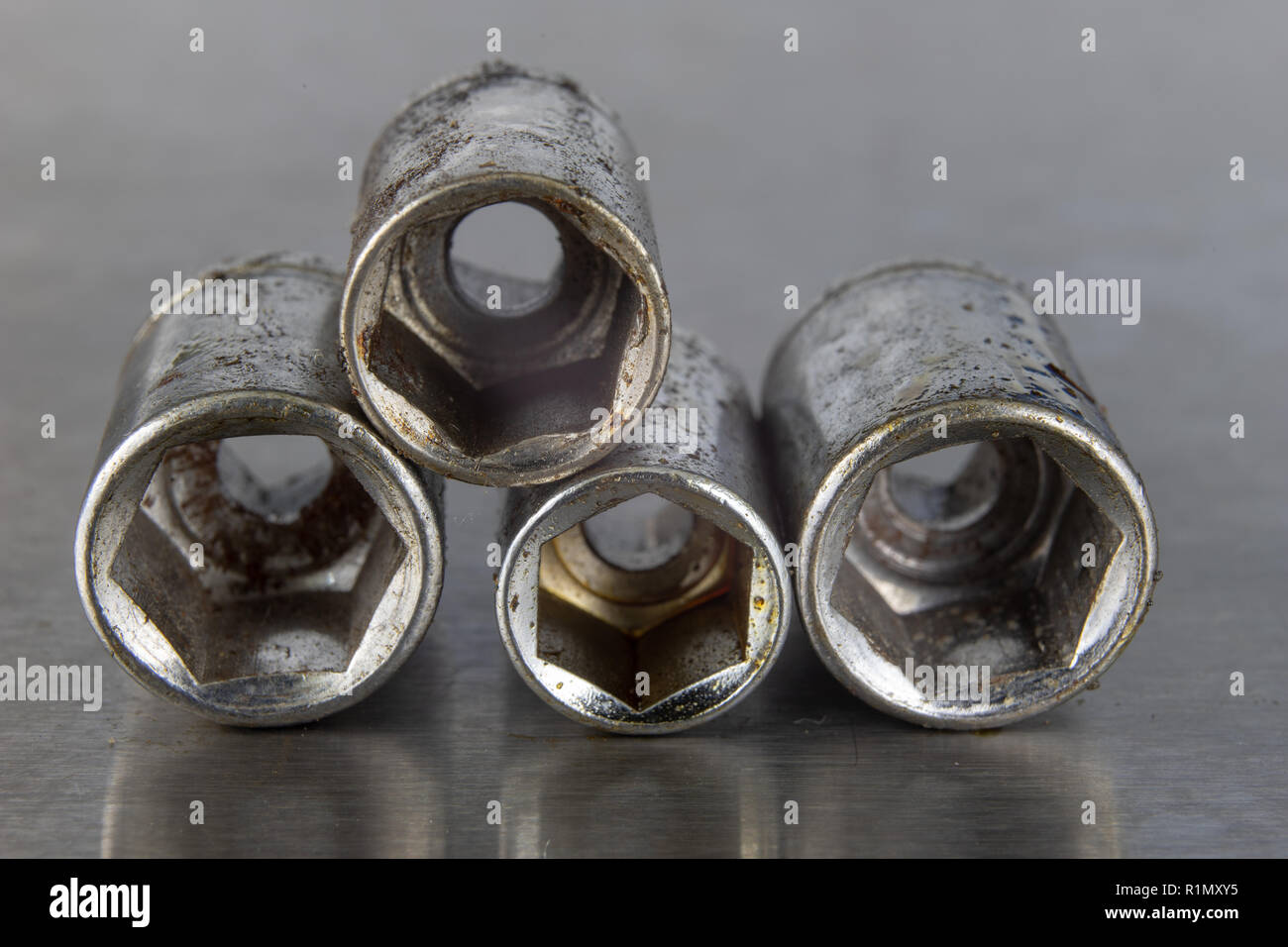 Old socket wrenches with a handle. Accessories for a workshop mechanic on a tin table. Light background. Stock Photo