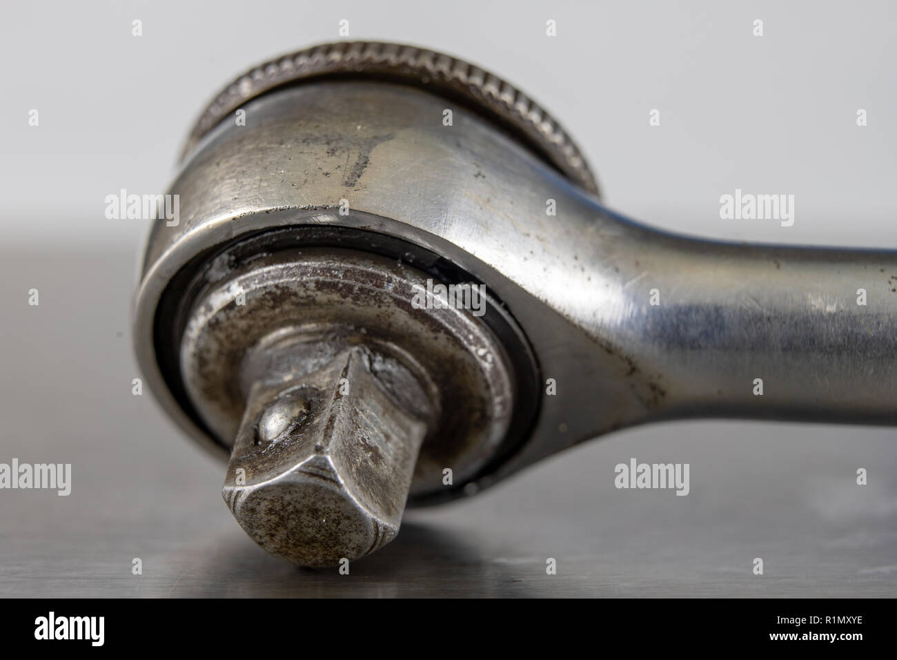 Old socket wrenches with a handle. Accessories for a workshop mechanic on a tin table. Light background. Stock Photo