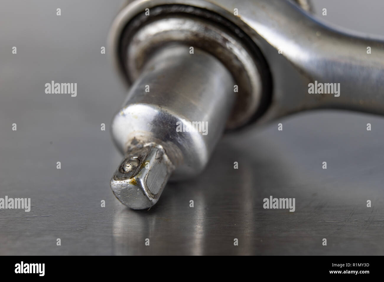 Old socket wrenches with a handle. Accessories for a workshop mechanic on a tin table. Light background. Stock Photo