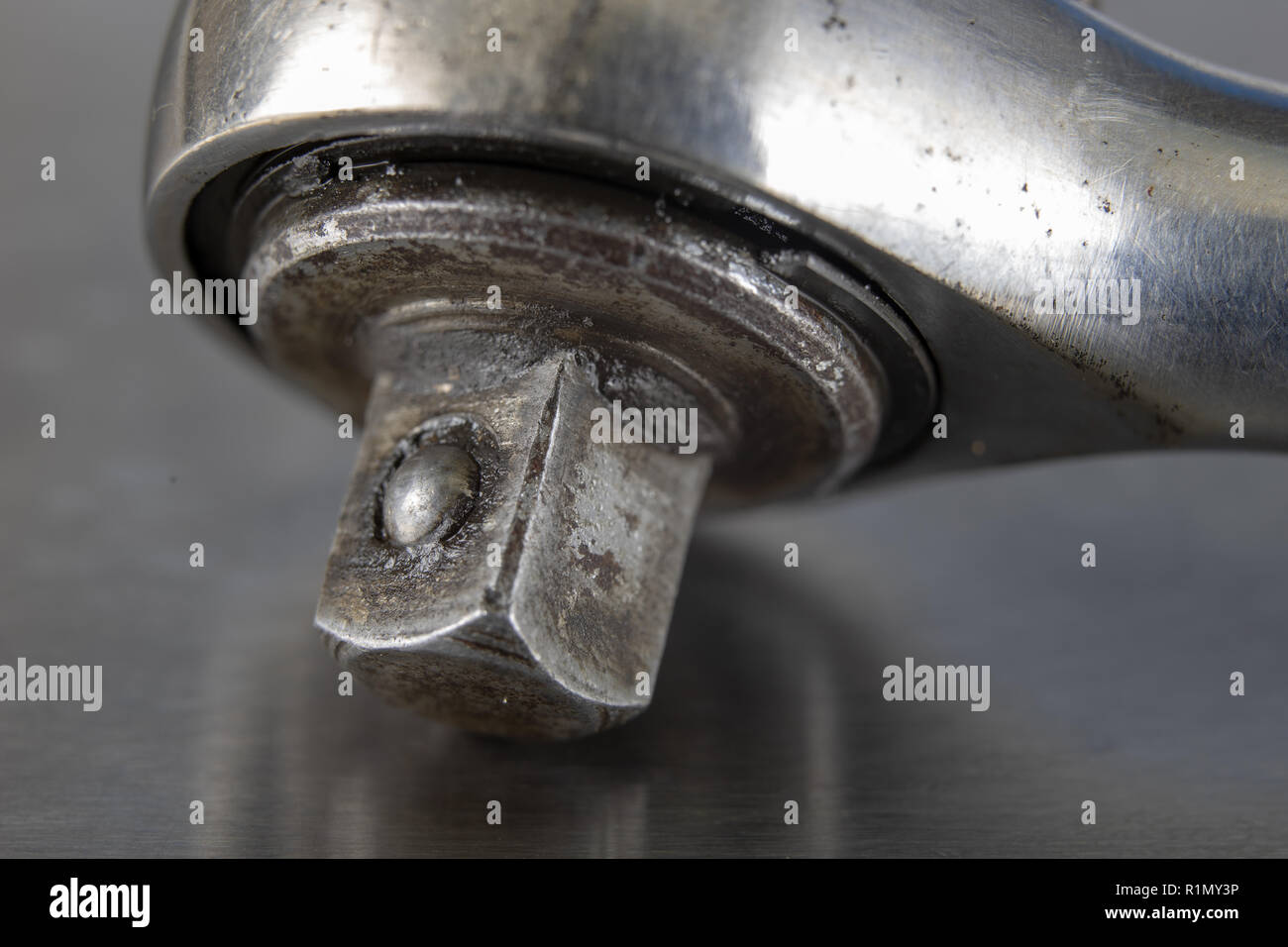 Old socket wrenches with a handle. Accessories for a workshop mechanic on a tin table. Light background. Stock Photo