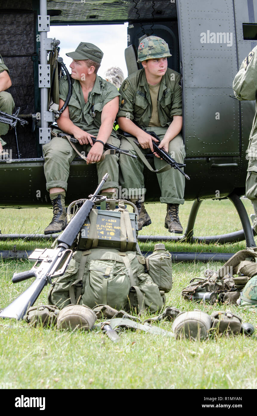 Vietnam War re-creation with US Marines re-enactors and vintage Huey gunship helicopter. Bell UH-1 Iroquois of US forces Stock Photo
