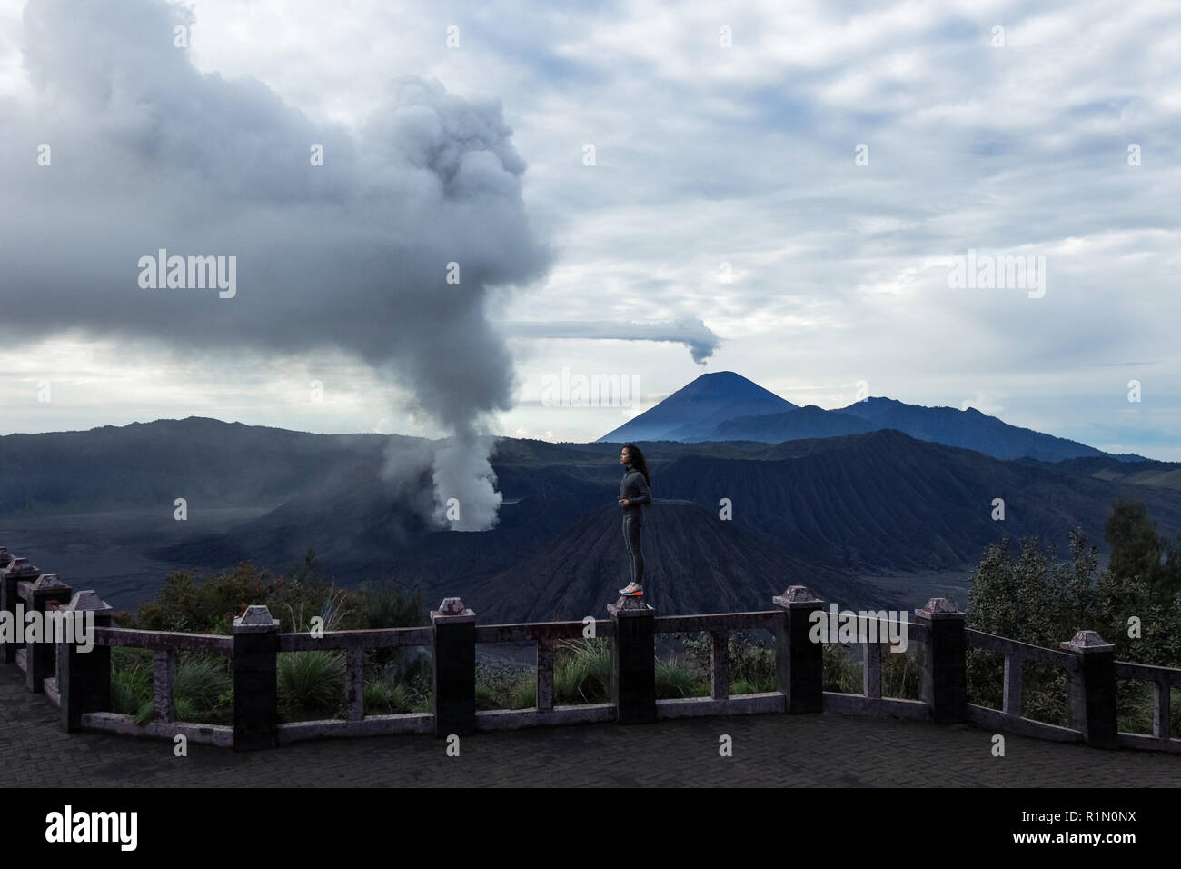 Woman watching Bromo volcano eruption Stock Photo