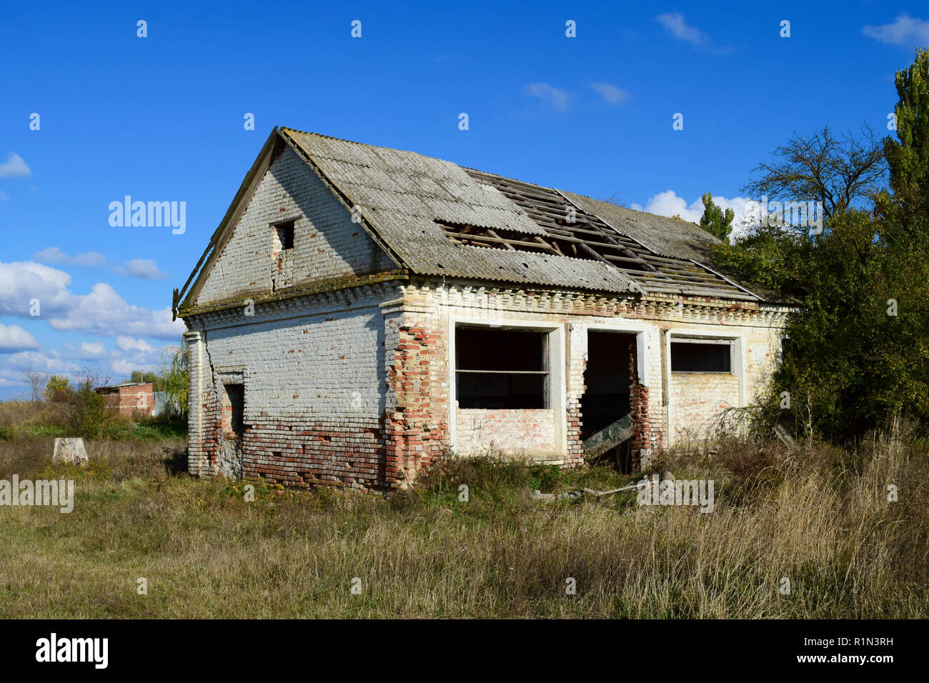 An old abandoned collapsing house. The broken roof and the falling brick from the walls Stock Photo