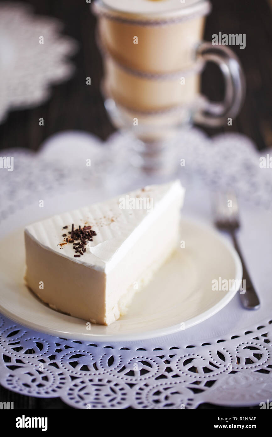 A piece of white cake with chocolate shavings Stock Photo