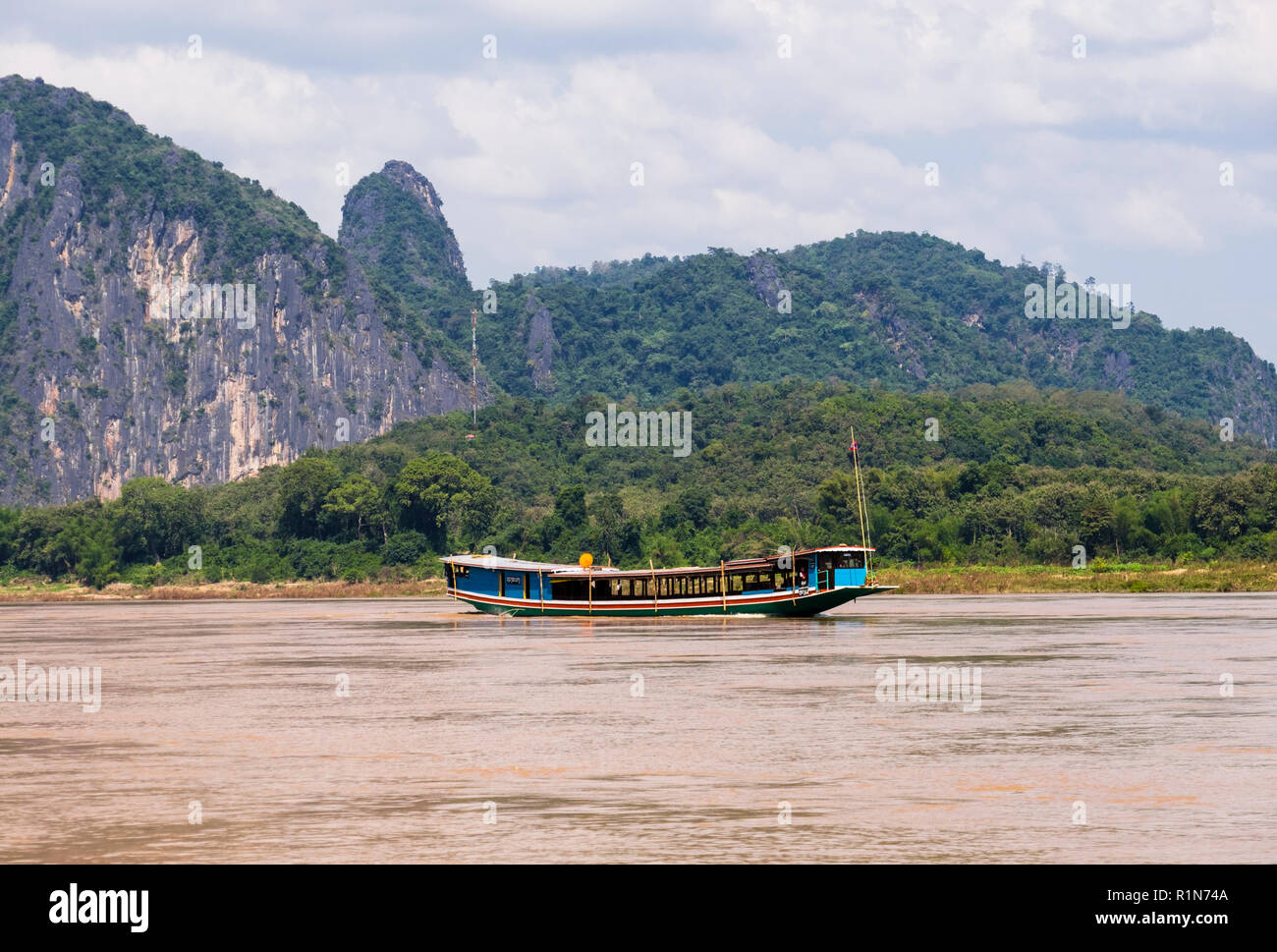 Traditional wooden tourists boat sailing on Mekong River trip. Pak Ou, Luang Prabang province, Laos, southeast Asia Stock Photo