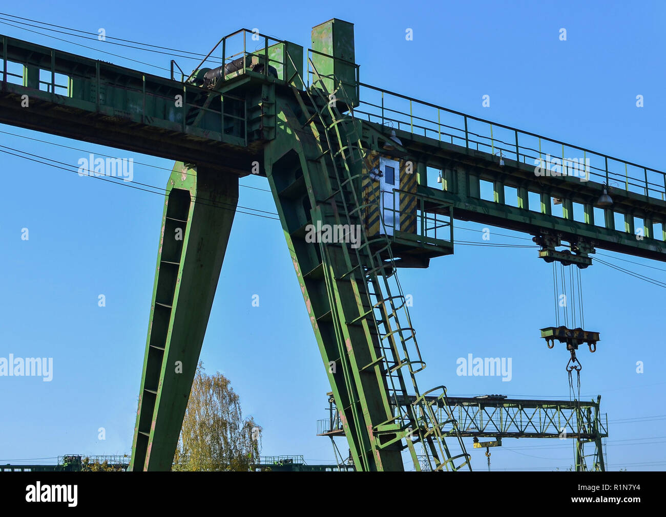 Gantry crane with hook for lifting and moving heavy cruz. Construction