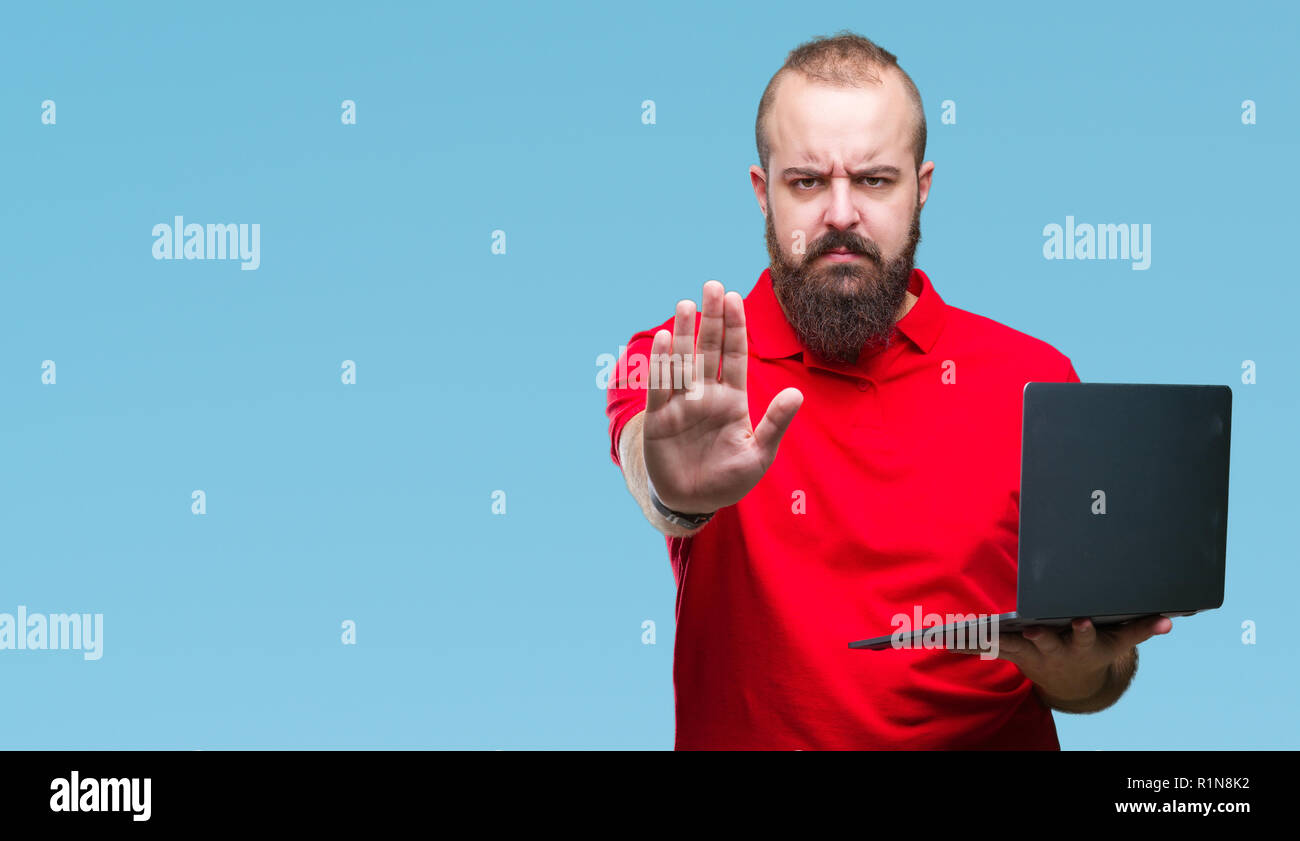 Young caucasian man using computer laptop over isolated background with ...