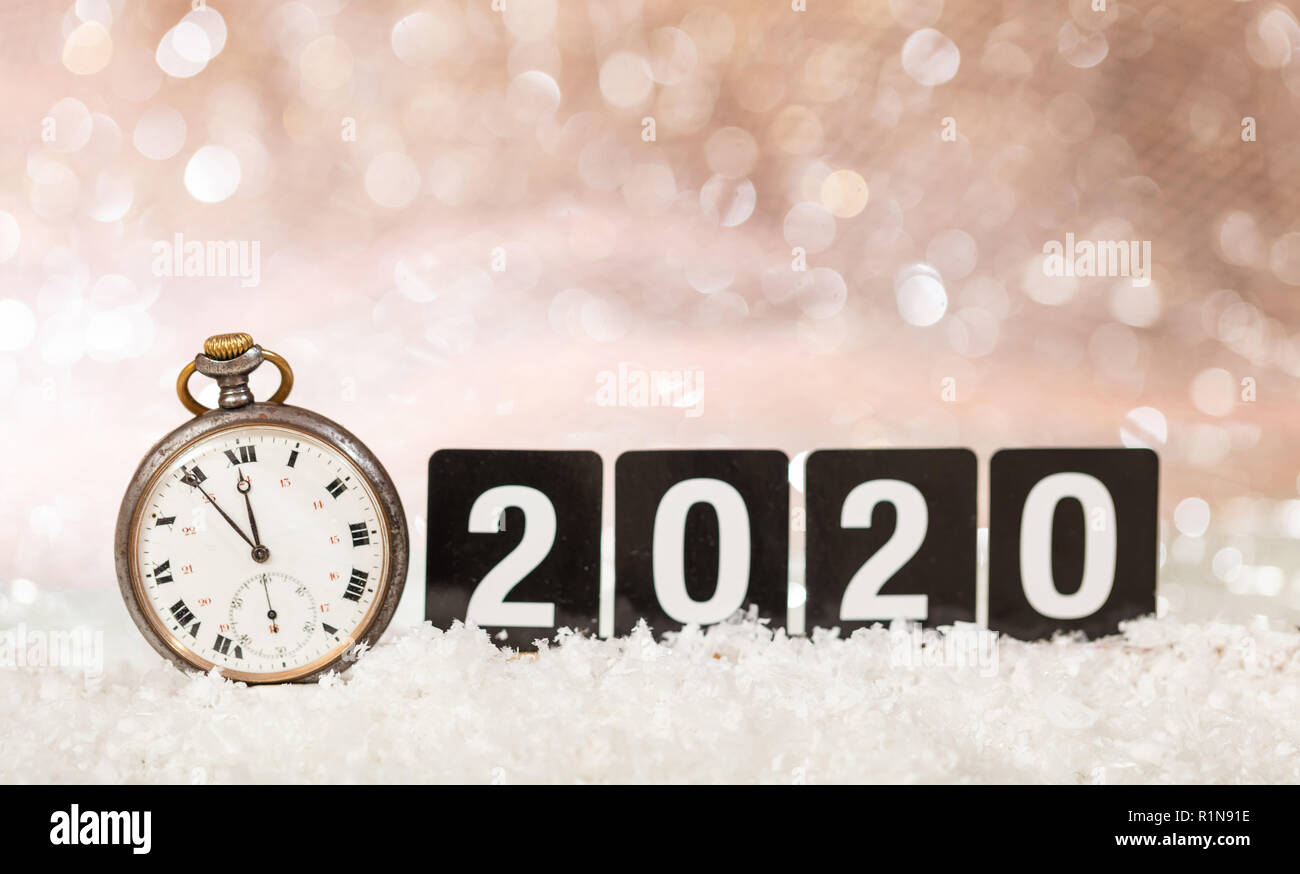 2020 New Years eve celebration. Minutes to midnight on an old watch, bokeh festive background Stock Photo