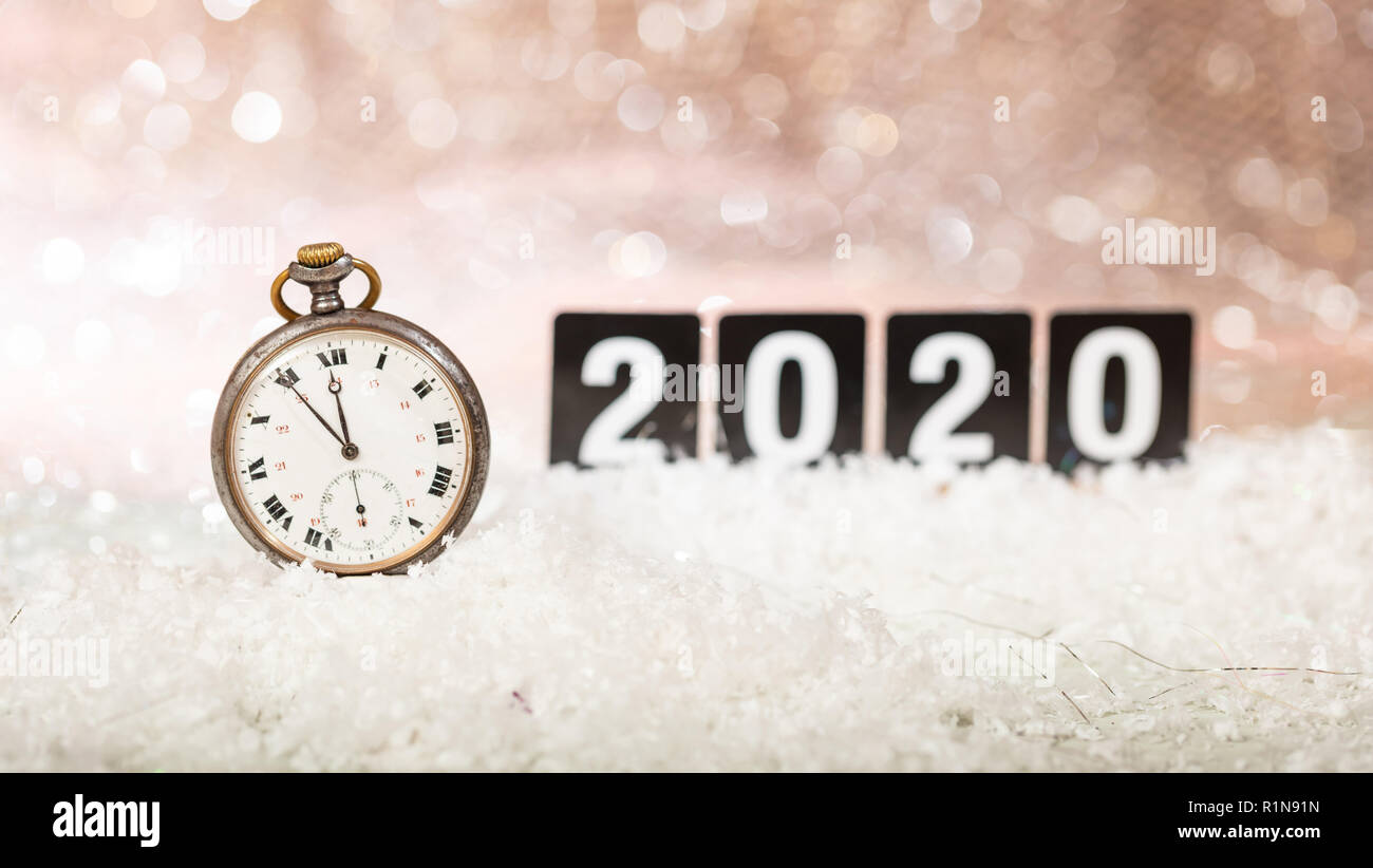 2020 New Years eve celebration. Minutes to midnight on an old watch, bokeh festive background Stock Photo