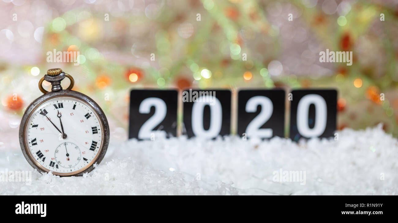 2020 New Years eve celebration. Minutes to midnight on an old watch, bokeh festive background, banner Stock Photo