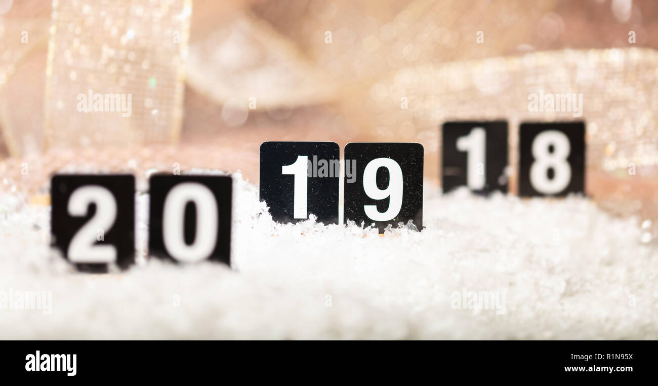 New year 2019 is coming concept. Numbers 18, 19, 20 on snow, focus on 19, abstract bokeh lights background Stock Photo