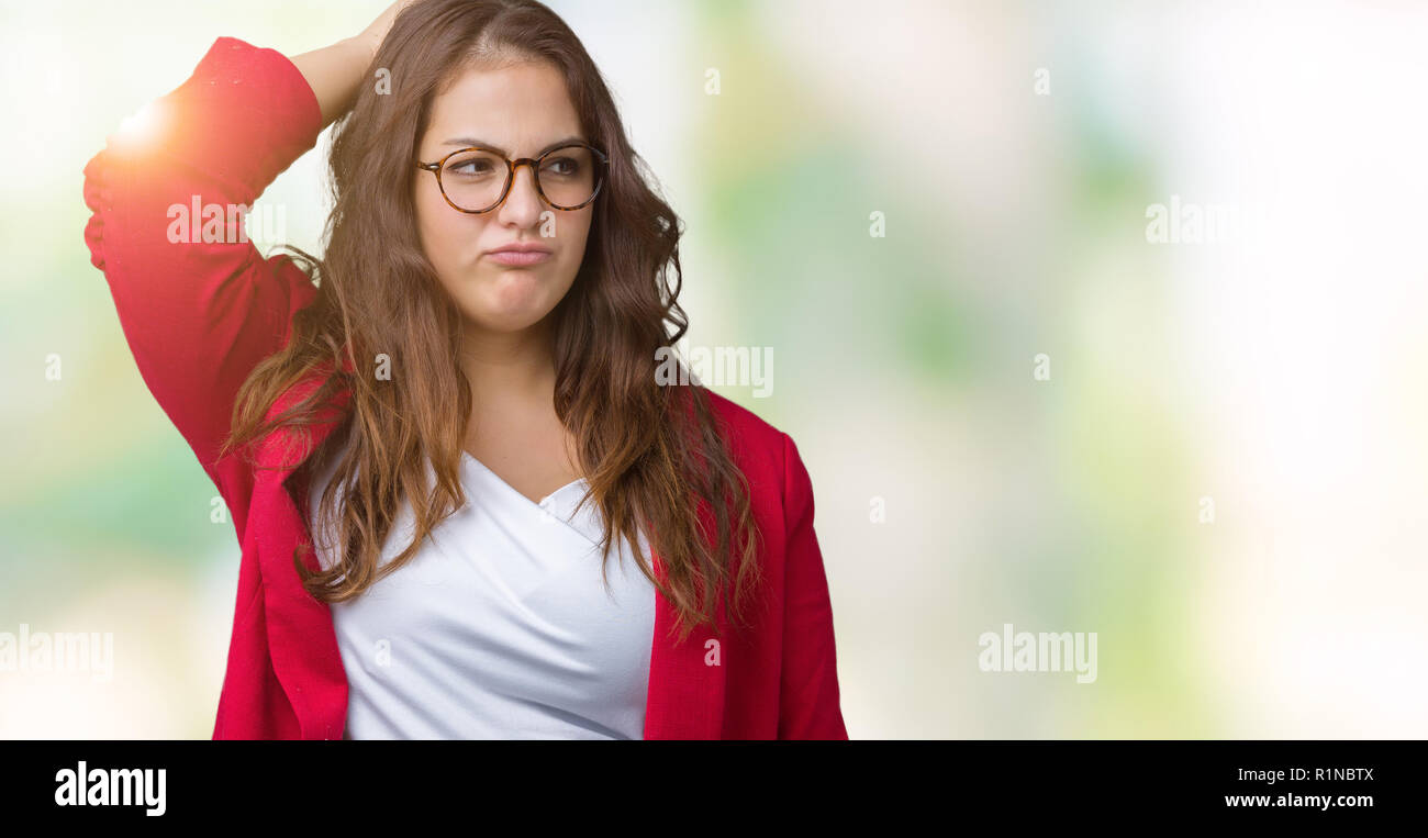 Beautiful plus size young business woman wearing elegant jacket and glasses over isolated background confuse and wonder about question. Uncertain with Stock Photo