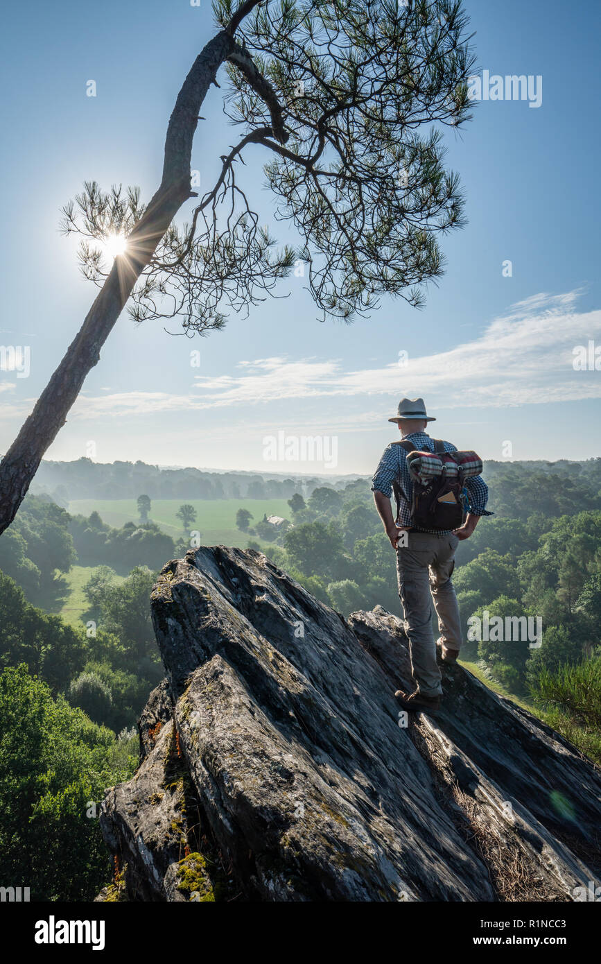 A man walking on a mountain trail overlooking the valley Stock Photo