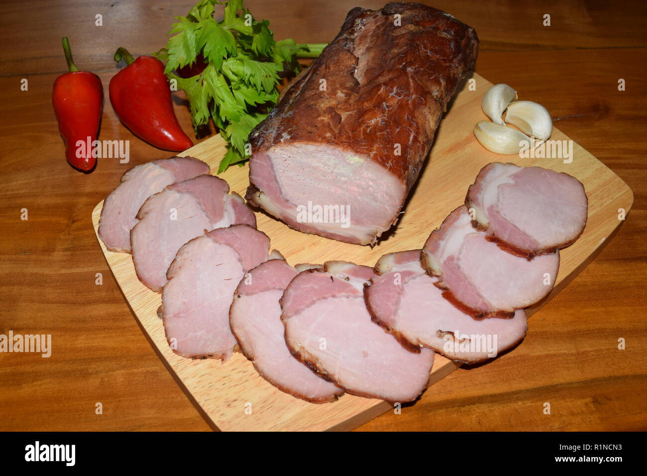 Kassler on wooden rustic plate. It is often served with sauerkraut and mashed potatoes. Fully Cooked cured and smoked pork loin chops on a wooden tray. Stock Photo