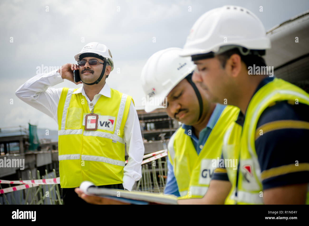 Safety officers working and talking over the phone at a construction site. Stock Photo