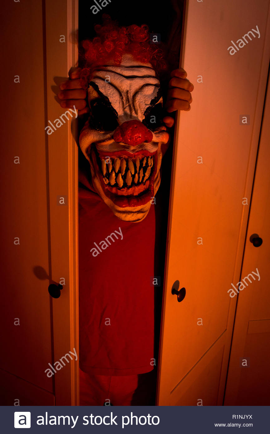 Child With Monster Mask Coming Out Of The Closet Stock Photo